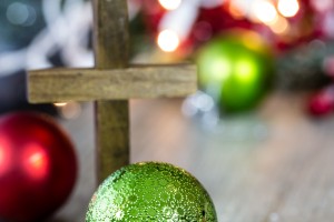 A wooden christmas cross with Christmas decorations.